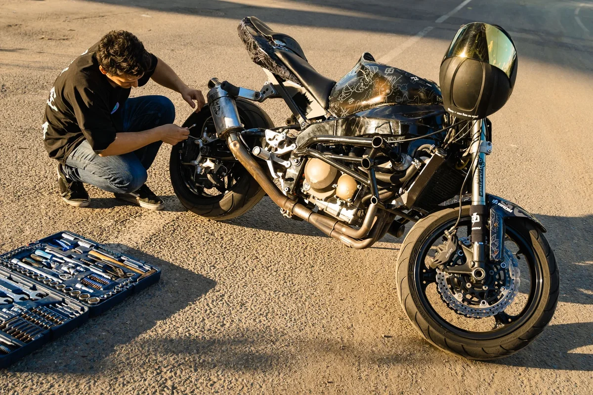 Coûts d'entretien d'une moto avec outils et pièces de rechange sur une table