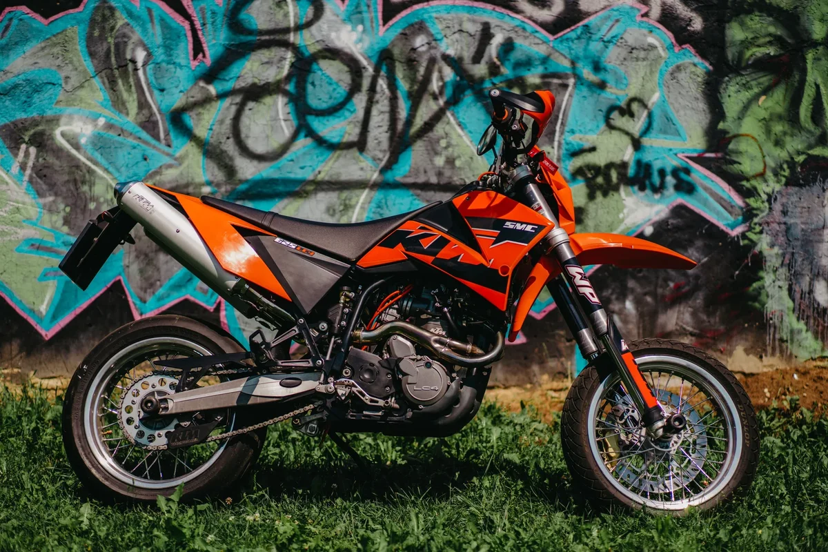 Ducati Hypermotard et KTM 690 SMC R côte à côte sur une route de montagne