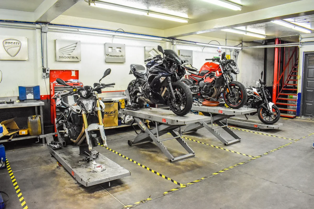 Outils de réparation de motos disposés sur une table dans un atelier spécialisé